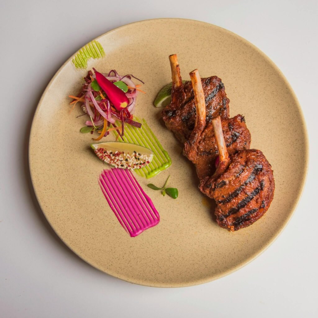 Delicious grilled lamb chops with vibrant garnish on a ceramic plate, ideal for gourmet presentations.